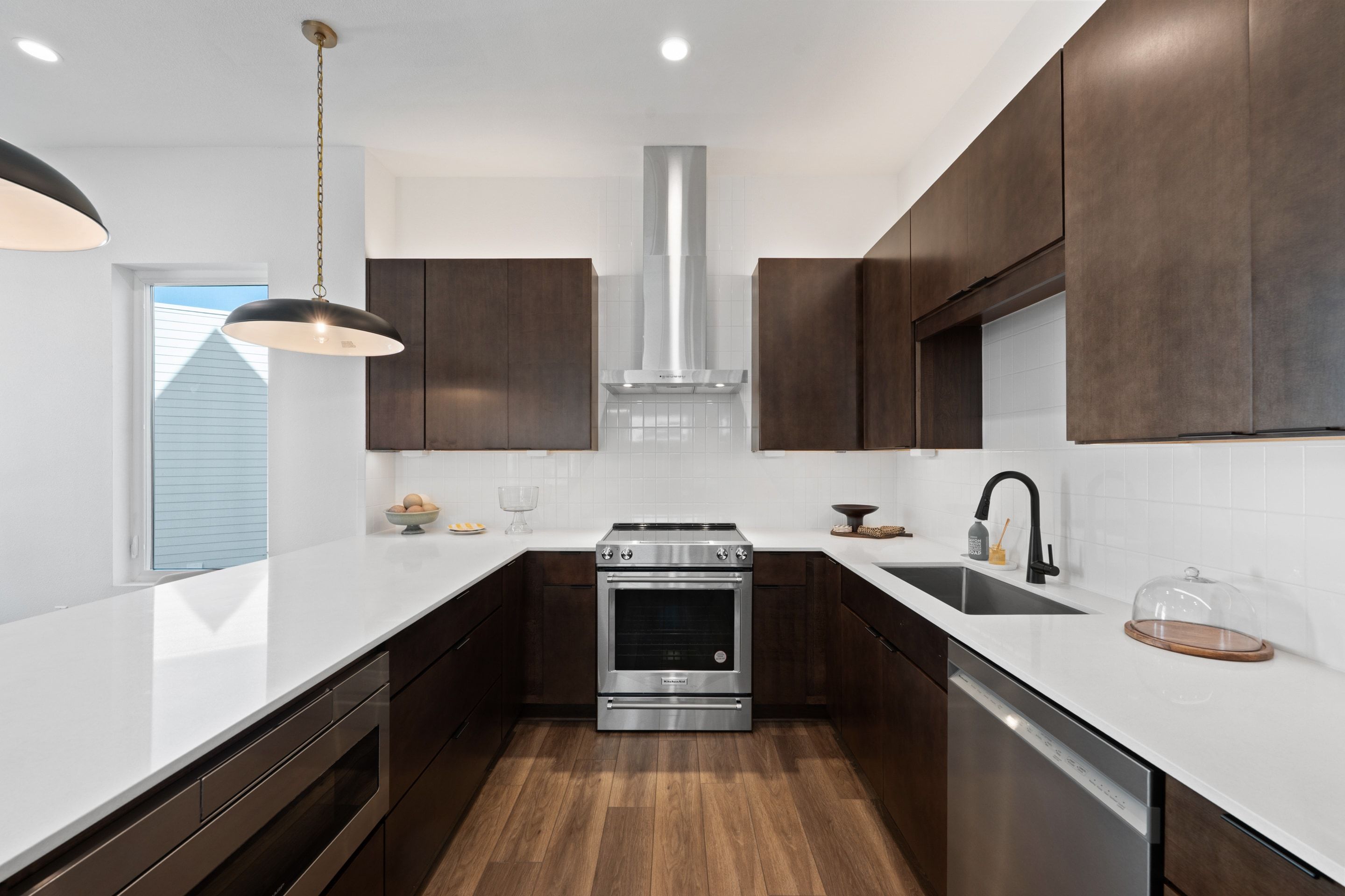 Overlook kitchen with quartz counters, walnut-tone cabinetry, and stainless appliances